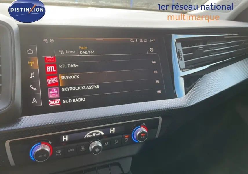Tableau de bord de l'Audi A1 Sportback 2023 avec écran tactile radio et commandes de climatisation visibles.