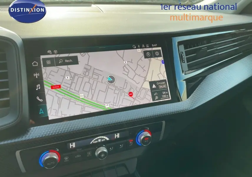 Vue rapprochée de l'écran tactile central et de la console de climatisation d'une Audi A1 Sportback blanche glacier 2023.