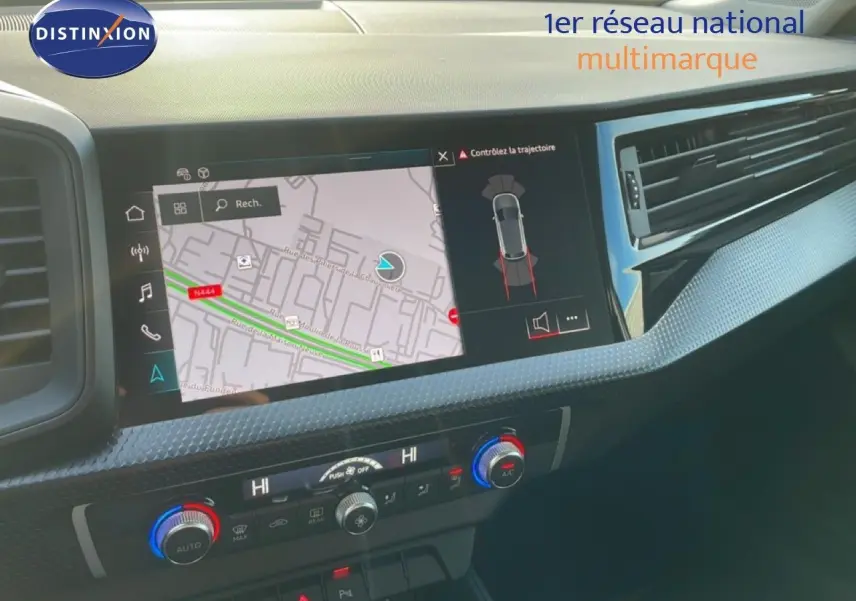 Intérieur de l'Audi A1 Sportback 2023 montrant la console centrale avec écran tactile GPS et commandes de climatisation.