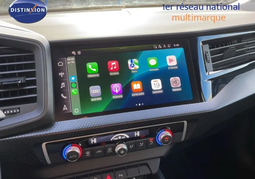 Vue rapprochée de la console centrale de l'Audi A1 Sportback 2023 avec écran tactile et commandes de climatisation.