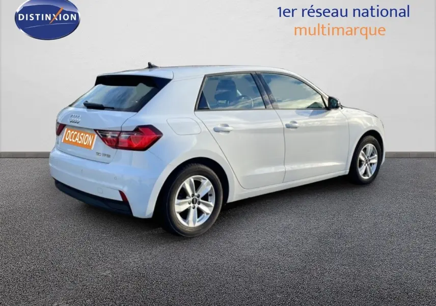Audi A1 Sportback blanc glacier vue 3/4 arrière côté droit sur fond neutre, avec jantes alliage 15 pouces.