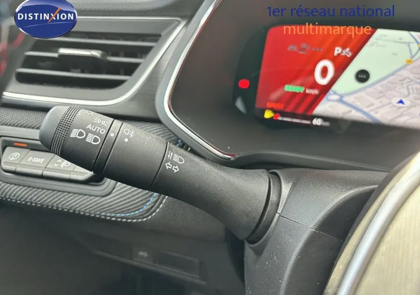 Gros plan sur la commande des phares et clignotants à gauche du volant d'une Renault Symbioz noire, tableau de bord numérique visible.