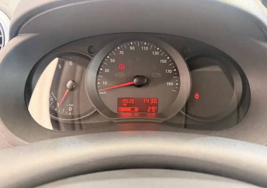 Vue rapprochée du tableau de bord du Renault Kangoo blanc, affichant le compteur et les voyants allumés.