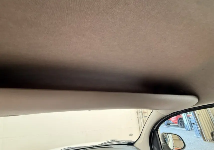 Vue intérieure côté passager du Renault Kangoo blanc 2016, montrant le pare-soleil et le rétroviseur extérieur.