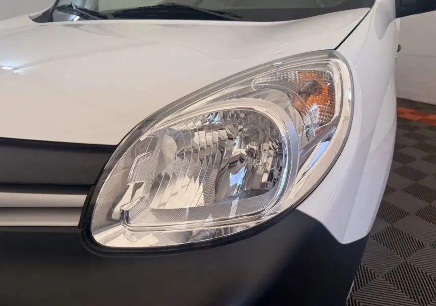 Gros plan sur le phare avant droit blanc d’un Renault Kangoo Confort Energy dCi 75 E6, avec calandre noire visible.