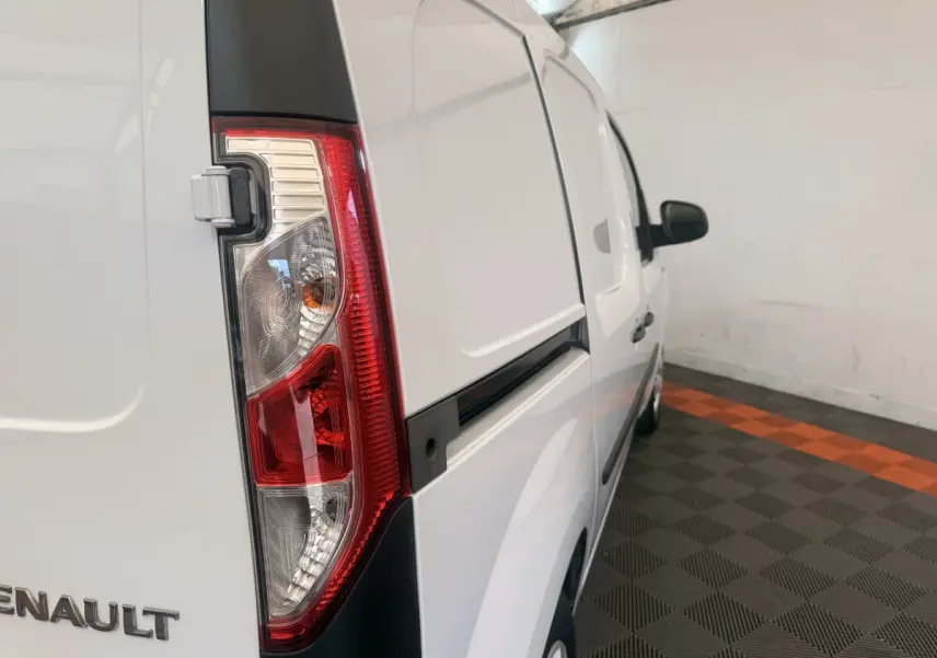 Vue 3/4 arrière droite d’un Renault Kangoo blanc avec feu arrière vertical et porte latérale coulissante.