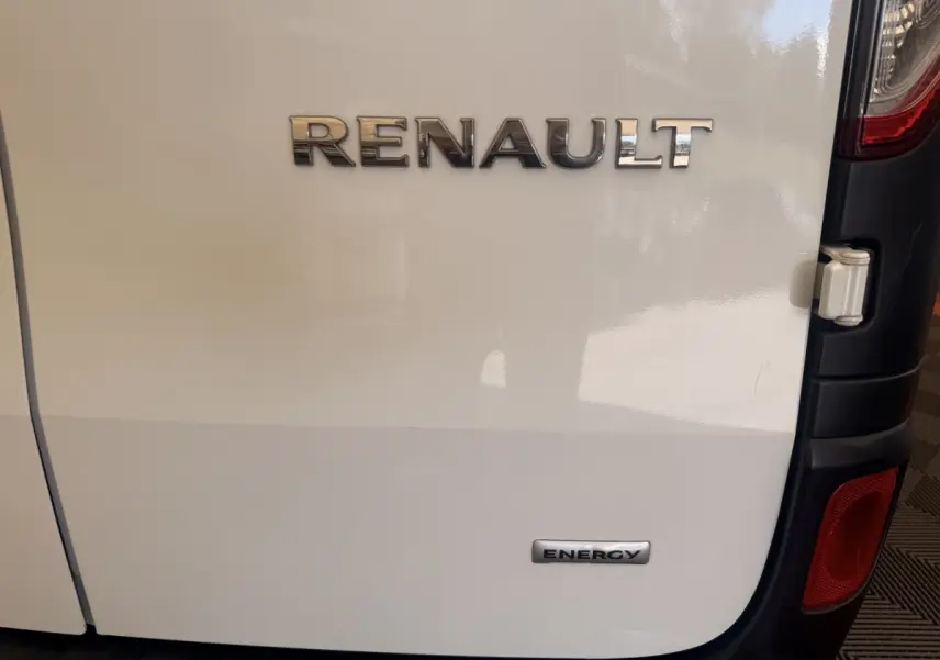 Gros plan sur la porte arrière droite blanche d’un Renault Kangoo avec logos Renault et Energy visibles.