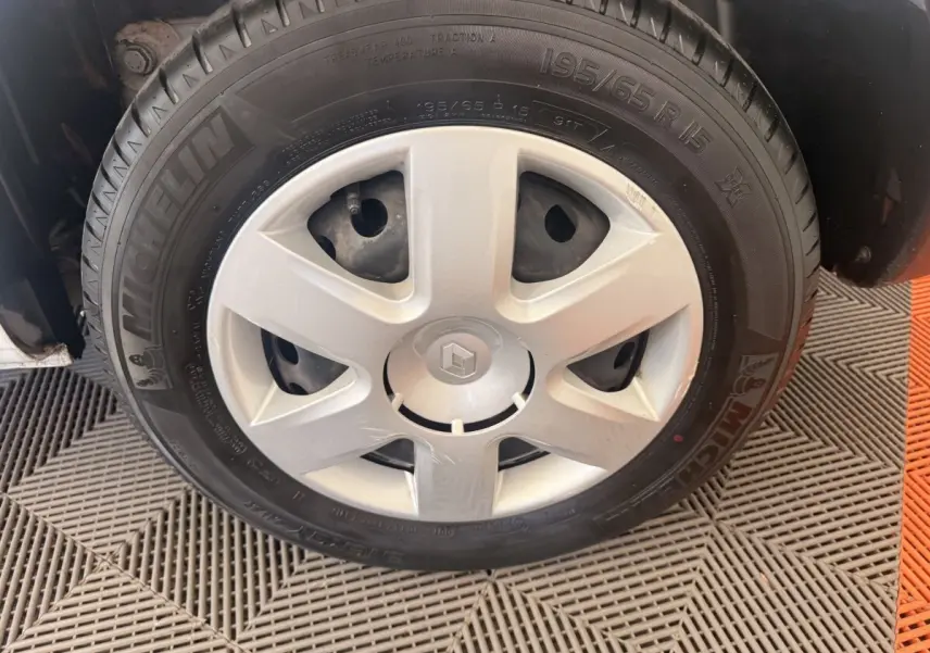 Gros plan sur la roue avant droite d’un Renault Kangoo blanc avec jante acier et pneu Michelin.