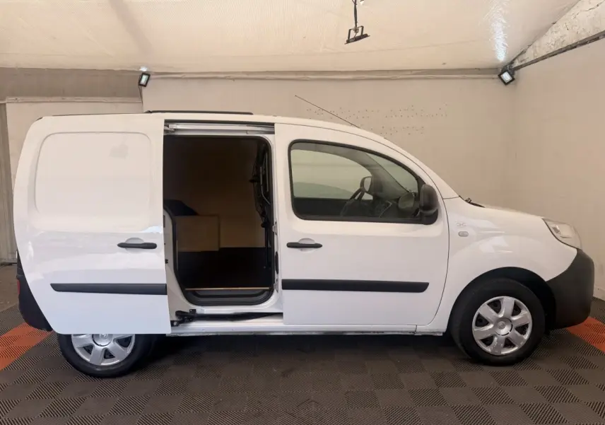 Profil droit d’un Renault Kangoo blanc 2016 avec porte latérale coulissante ouverte, intérieur de chargement visible.