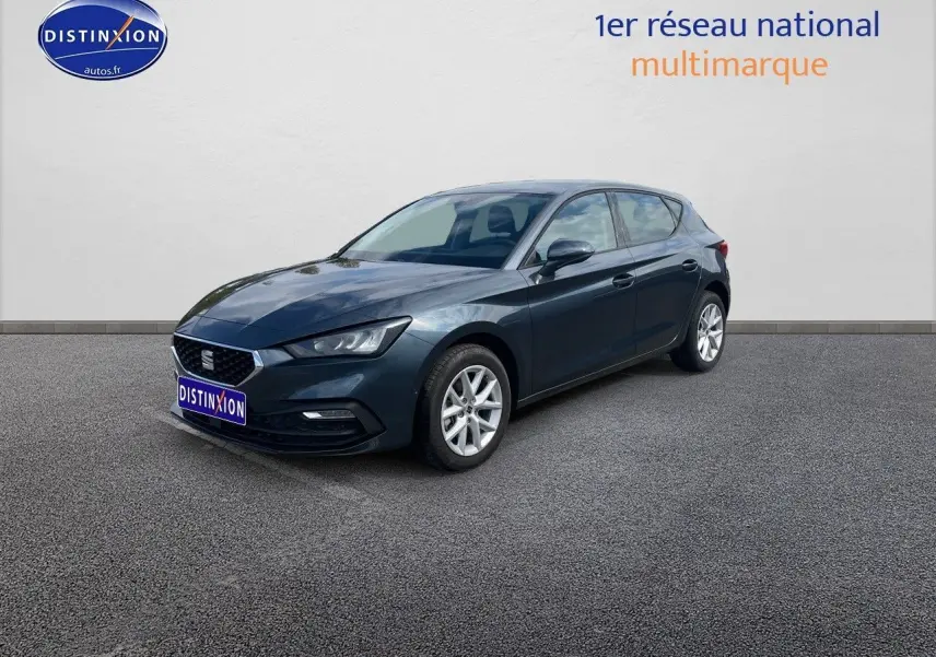 SEAT Leon IV gris magnétique métal vue 3/4 avant droit, mettant en valeur ses lignes dynamiques et jantes argentées.