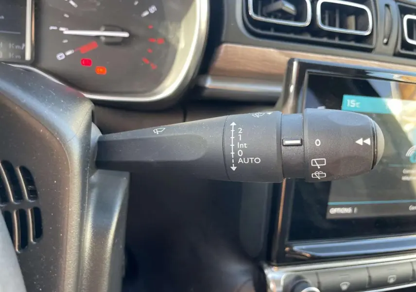 Gros plan sur la commande d’essuie-glace à gauche du volant dans l’habitacle d’une Citroën C3 gris foncé 2021.