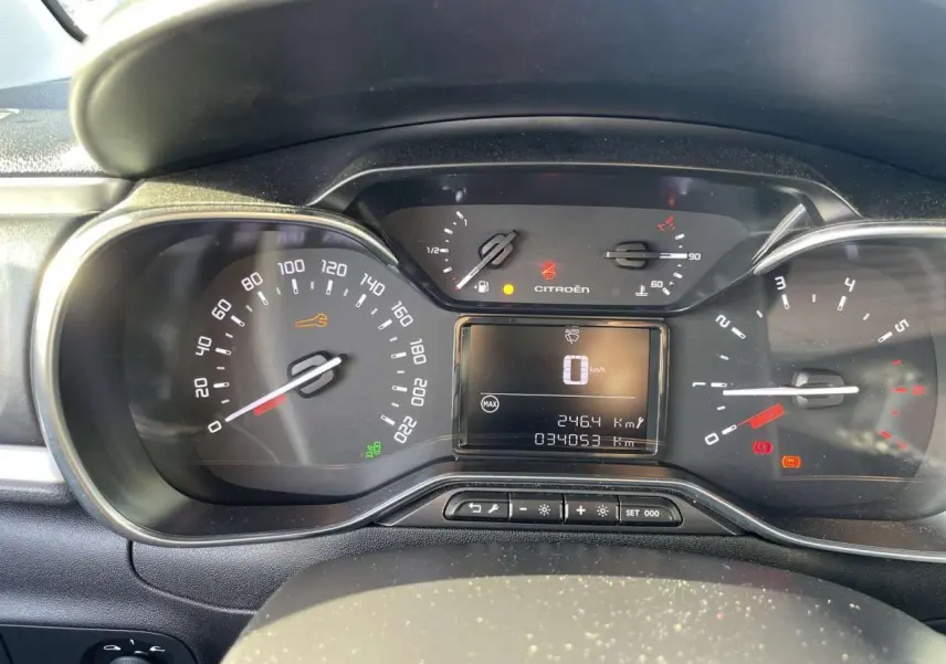 Vue rapprochée du tableau de bord de la Citroën C3 1.2 Shine 2021, affichant le compteur et les voyants allumés.