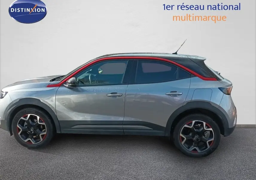 Profil droit d'un Opel Mokka GS Line 2022 gris quartz avec toit noir et détails rouges sur les jantes et la ligne de toit.