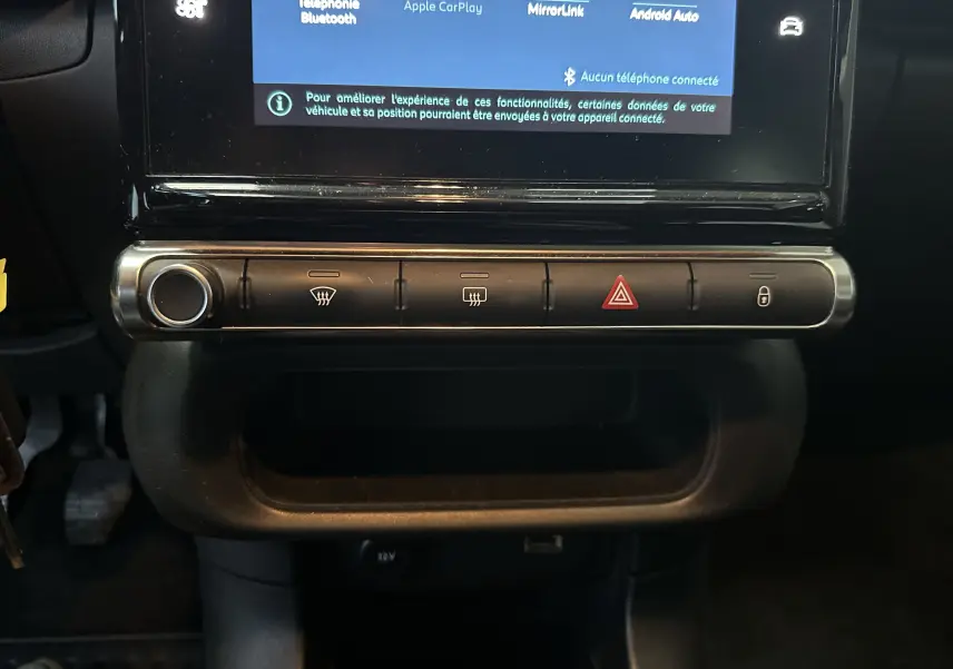 Vue rapprochée de la console centrale de la Citroën C3 blanche, montrant les boutons de commande et l'écran tactile.