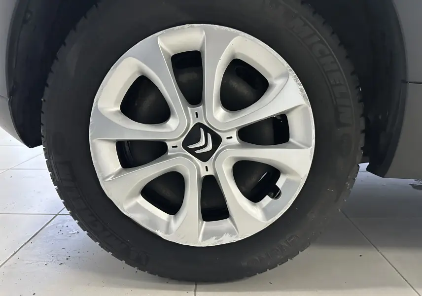 Gros plan sur la jante en alliage argentée avec logo Citroën, montée sur un pneu Michelin noir.