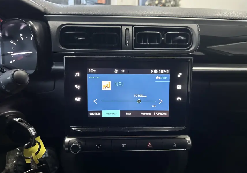 Vue rapprochée de l’écran tactile central et tableau de bord noir d’une Citroën C3 blanche de 2018.