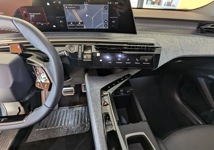 Vue intérieure côté conducteur du Peugeot 3008 Hybrid 2026, tableau de bord moderne avec écran tactile et volant multifonction.
