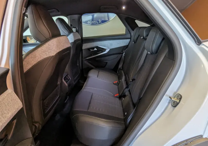 Vue intérieure arrière côté droit du Peugeot 3008 blanc Okenite, montrant les sièges arrière en tissu et cuir avec surpiqûres contrastées.