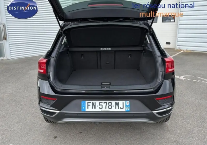 Vue arrière d’un Volkswagen T-Roc noir 2020 avec coffre ouvert, montrant l’espace de chargement vide.