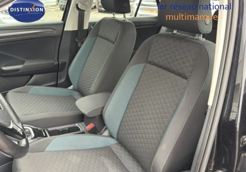 Vue intérieure côté gauche du Volkswagen T-Roc noir 2020, mettant en valeur les sièges avant en tissu gris à motifs.