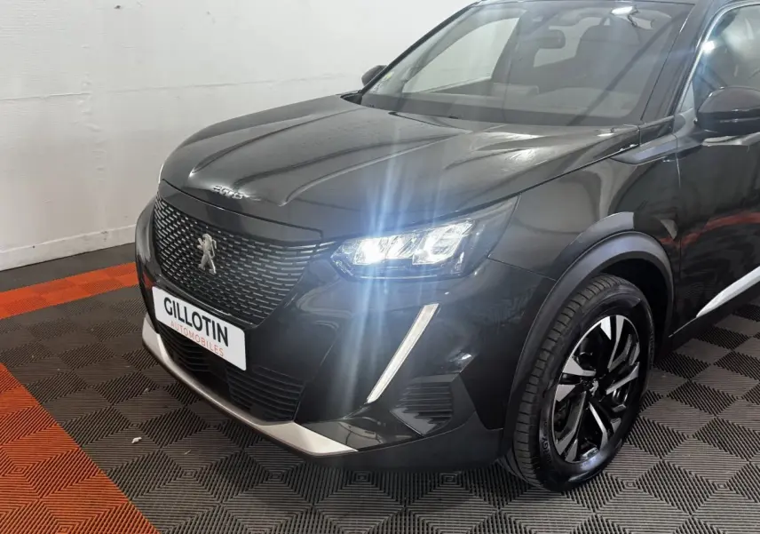 Peugeot 2008 noir vue 3/4 avant droit avec phares LED allumés et jantes alliage distinctives.