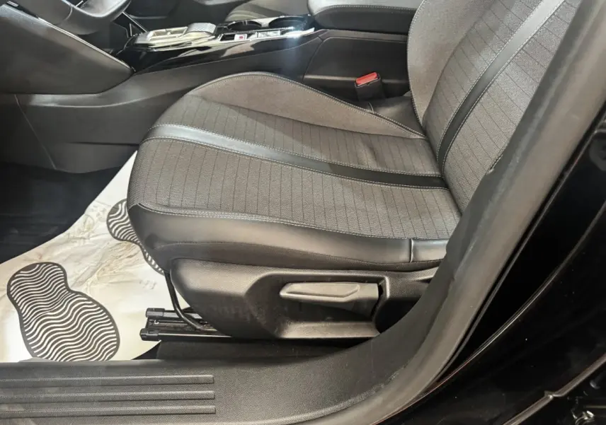 Vue intérieure côté conducteur du siège avant en tissu et cuir noir du Peugeot 2008 BlueHDi 130 de 2022.