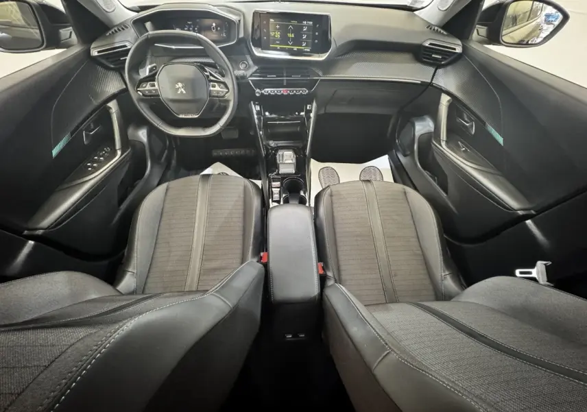 Vue intérieure avant du Peugeot 2008 noir 2022, montrant le volant cuir multifonctions et l’écran tactile central.