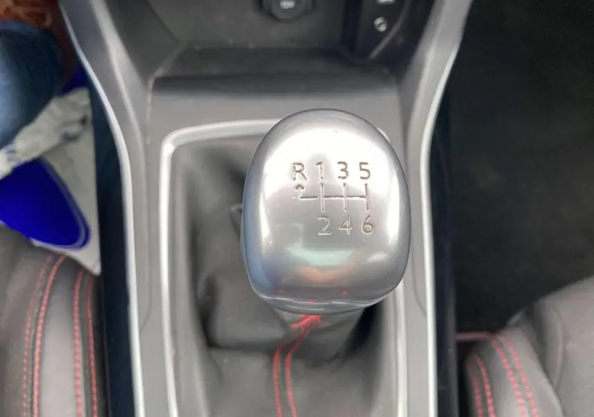 Le levier de vitesse manuel argenté de la Peugeot 308 SW GT Line 2017 avec surpiqûres rouges sur les sièges en tissu.