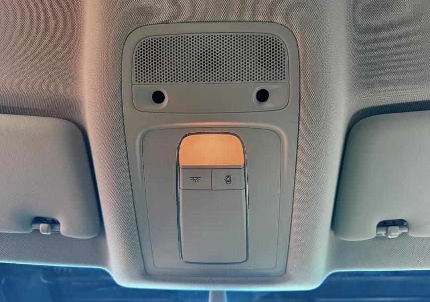 Plafonnier intérieur allumé avec commandes d’éclairage et de verrouillage, vue centrée vers l’avant de l’Audi Q3 noire.