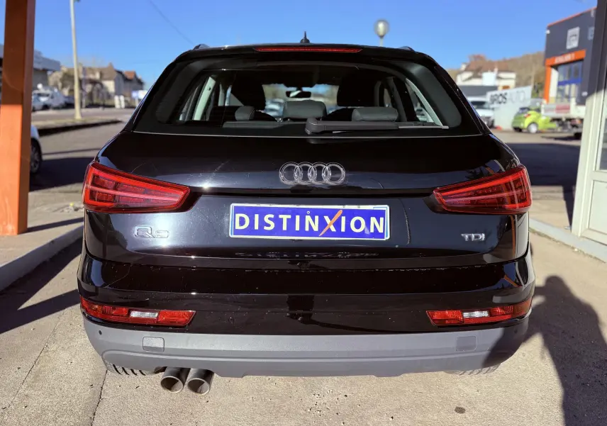 Vue arrière d'un Audi Q3 noir de 2016 avec double sortie d'échappement et feux arrière LED allumés.