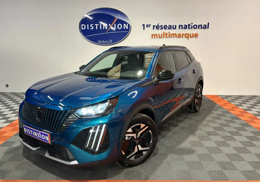 Peugeot 2008 II Ph.2 Allure Hybrid bleu Obsession vue 3/4 avant droit en intérieur showroom avec éclairage LED.