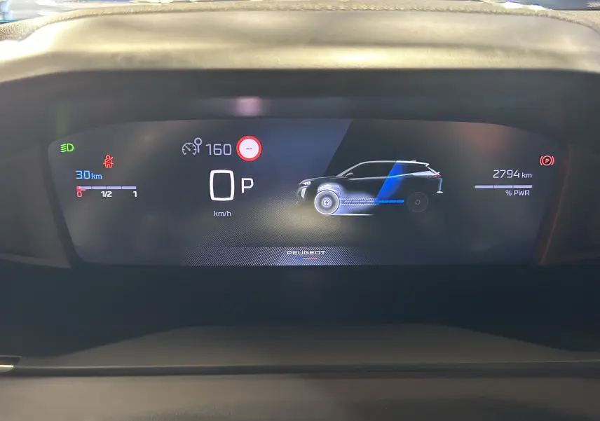 Vue du tableau de bord numérique du Peugeot 2008 Hybrid 2025, affichant la vitesse, autonomie et schéma du véhicule en mode stationnement.