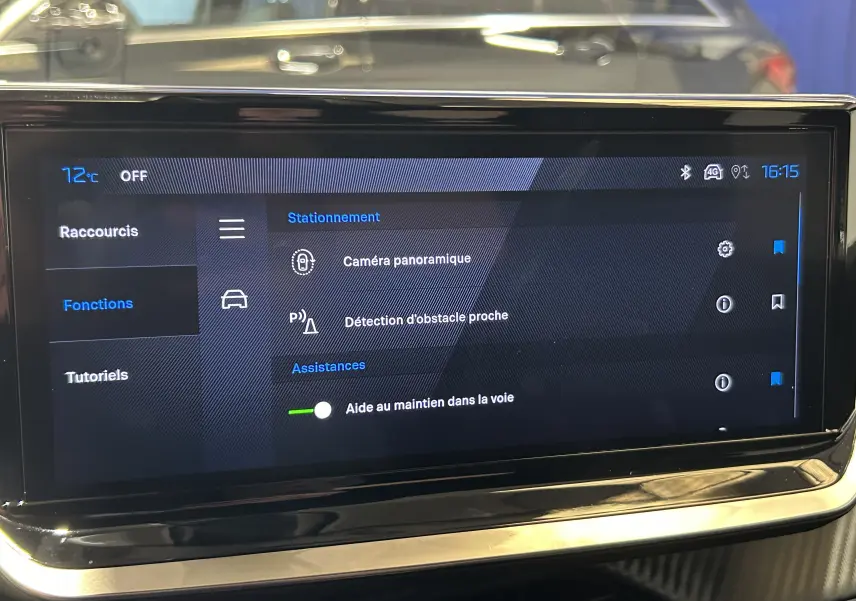 Écran tactile central du Peugeot 2008 bleu Obsession montrant les options d'assistance à la conduite et caméra panoramique.