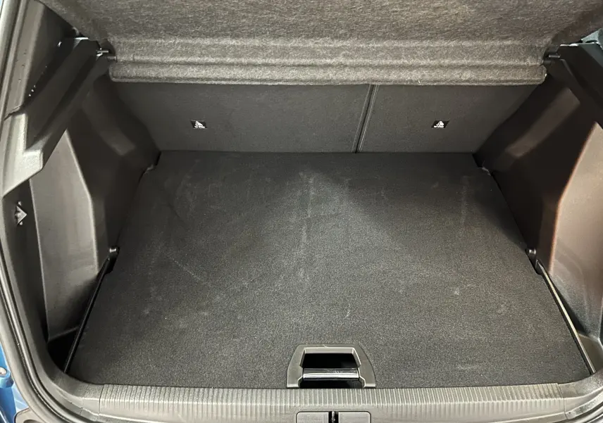 Coffre ouvert vu de face du Peugeot 2008 bleu Obsession, montrant l'espace de rangement vide et le plancher plat.