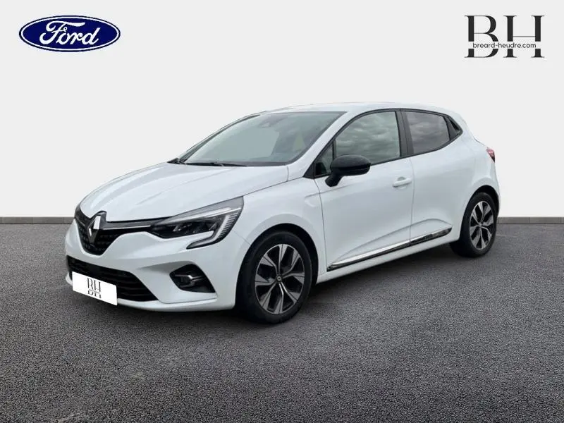 Renault Clio blanc glacier vue 3/4 avant droit avec jantes alliage et rétroviseurs noirs.