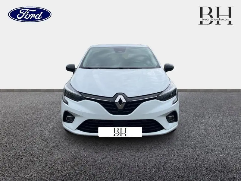 Vue avant d'une Renault Clio blanche 2022 avec calandre noire et phares LED, sur fond neutre.