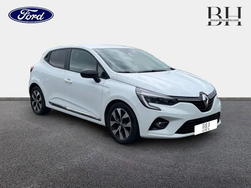 Renault Clio blanc Glacier vue 3/4 avant droit avec jantes alliage et rétroviseurs noirs.