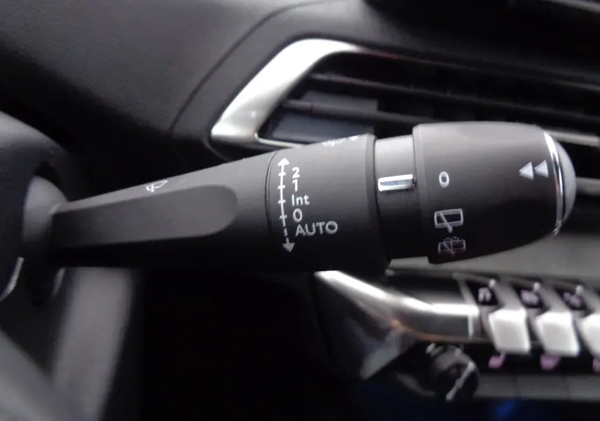 Gros plan sur la commande d’essuie-glace du Peugeot 5008 gris platinium, montrant les réglages automatiques et manuels.