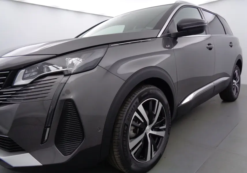 Vue 3/4 avant droit du Peugeot 5008 gris platinium métal avec jantes alliage et feux LED distinctifs.