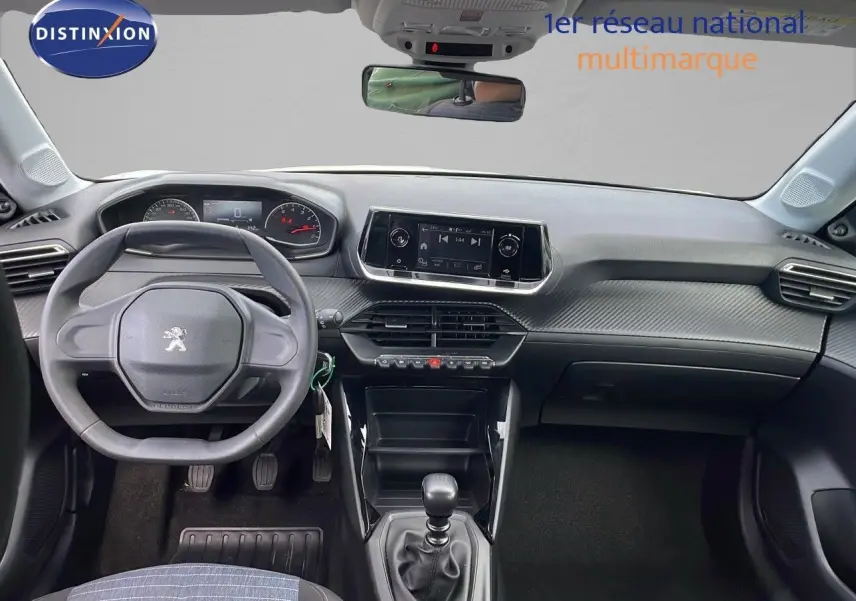 Vue intérieure du tableau de bord et volant de la Peugeot 208 blanche banquise version Société 2021 avec boîte manuelle.