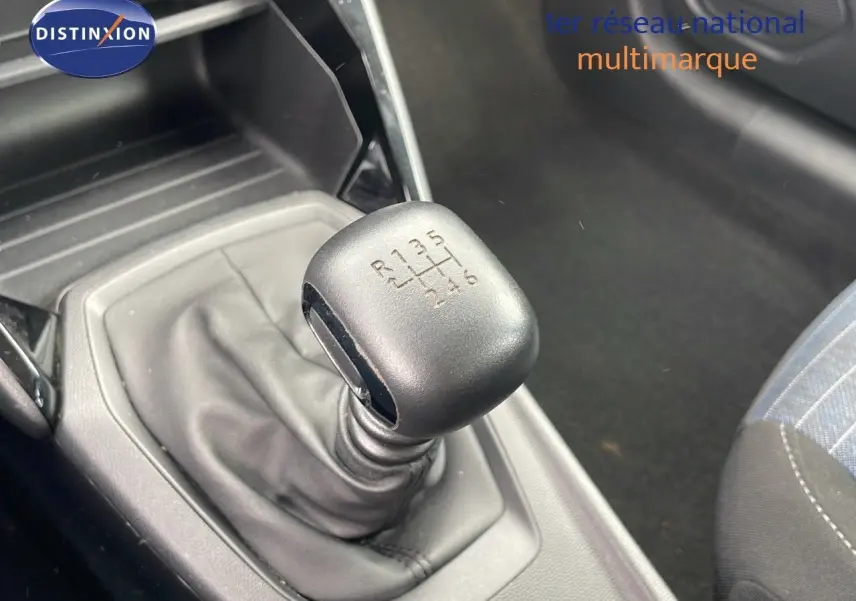 Le levier de vitesses manuel 6 rapports de la Peugeot 208 blanche, avec console et partie du siège côté passager.