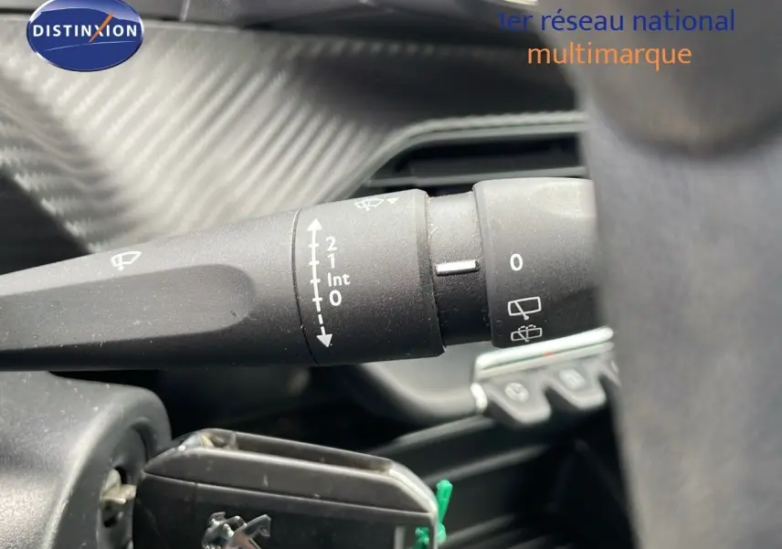 Gros plan sur la commande des essuie-glaces dans l'habitacle d'une Peugeot 208 blanche banquise.