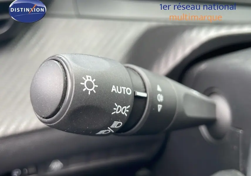 Gros plan sur la commande des phares de la Peugeot 208 blanche, version Société 1.5 HDI 2021, intérieur noir.