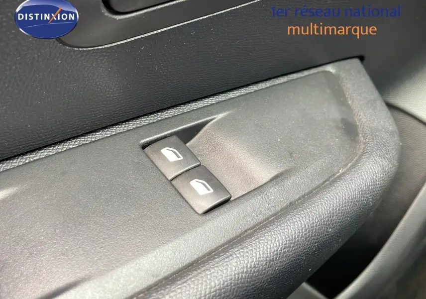 Gros plan sur les commandes des vitres électriques côté conducteur d'une Peugeot 208 blanche banquise 2021.