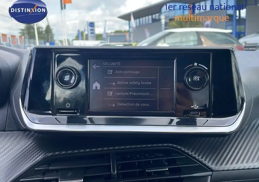 Écran tactile central de la Peugeot 208 blanc banquise 2021 affichant les options de sécurité du véhicule.