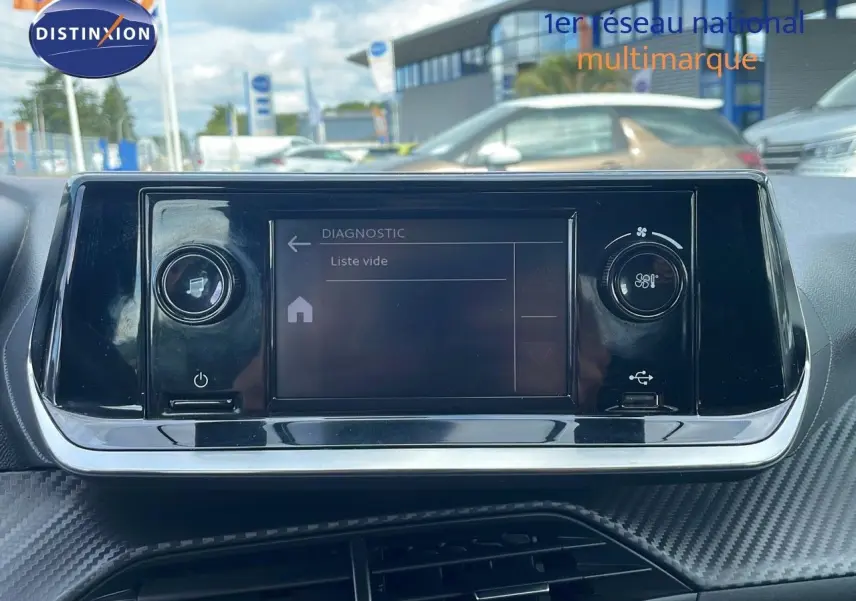 Écran tactile central du tableau de bord de la Peugeot 208 blanc banquise, avec commandes de climatisation visibles.