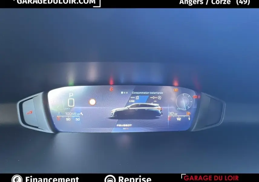 Affichage numérique du tableau de bord de la Peugeot 308 gris clair, montrant la consommation instantanée et la vitesse.