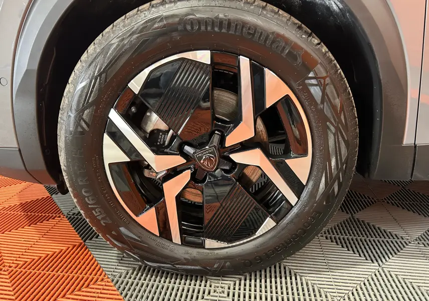 Gros plan sur la roue avant droite du Peugeot 2008 gris Selenium, mettant en valeur la jante bi-ton et le pneu Continental.