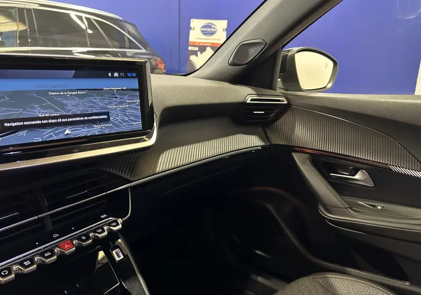 Vue intérieure côté passager du tableau de bord et écran tactile avec navigation de la Peugeot 2008 II Ph.2 Allure Hybrid 2025.