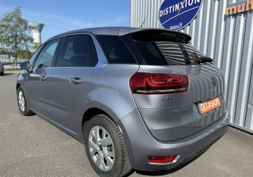 Vue 3/4 arrière droite d'une Citroën C4 Picasso gris métallisé avec feux arrière LED et vitres teintées.